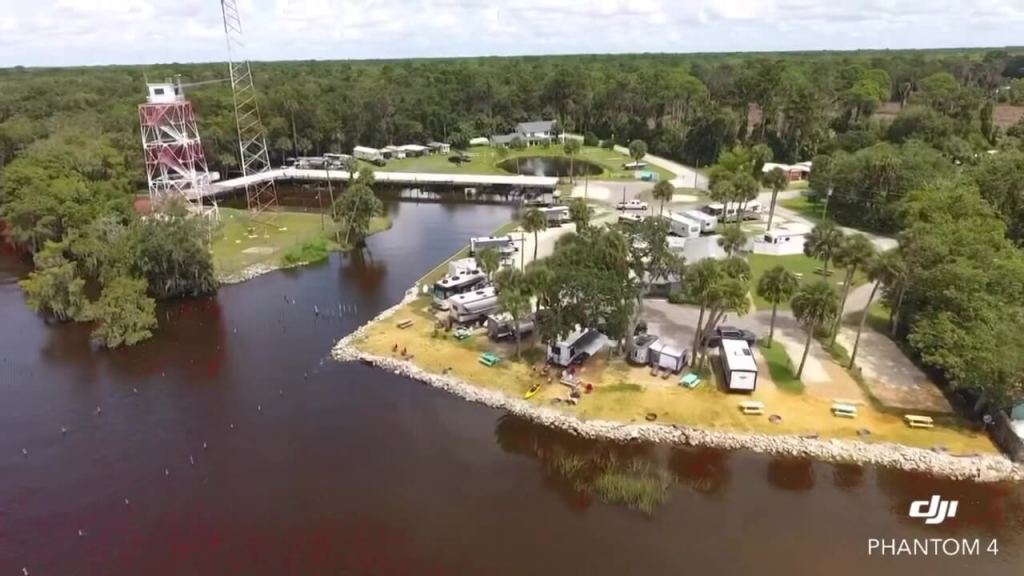 Daytime view of RV site with turquoise picnic tables and wide open lake