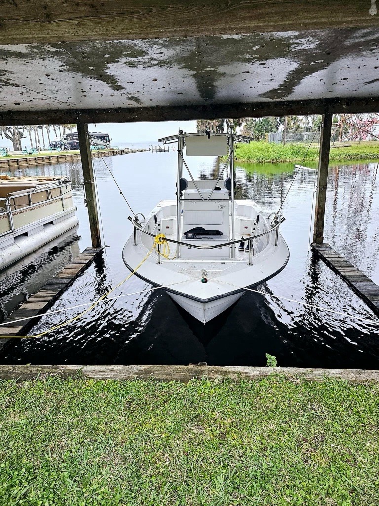 Waterfront marina with covered boat slips and RV in foreground